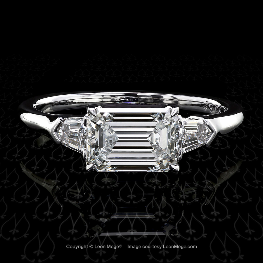 East-West set custom engagement ring with an emerald cut diamond by Leon Mege.