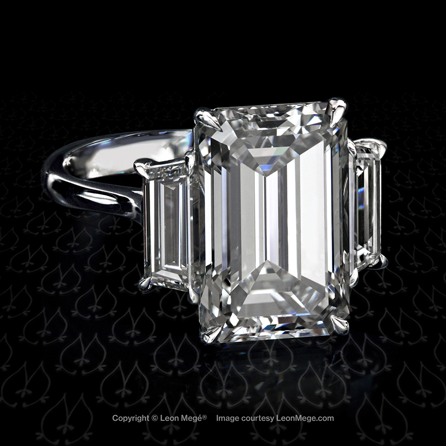Classic three-stone ring featuring an emerald cut diamond by Leon Mege.