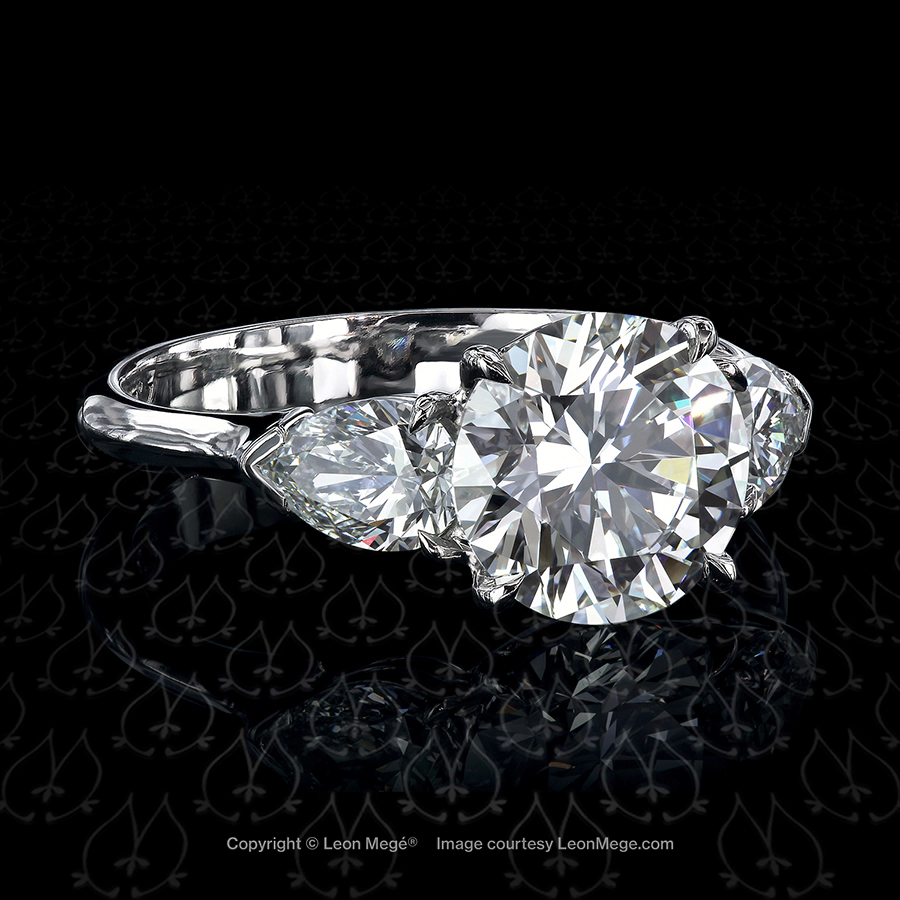 Three-stone engagement ring featuring a round diamond by Leon Mege.