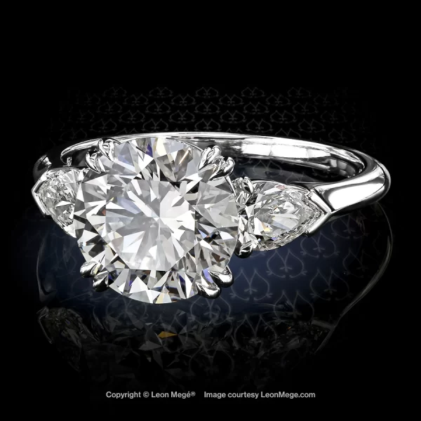 Three-stone engagement ring featuring a round brilliant by Leon Mege.