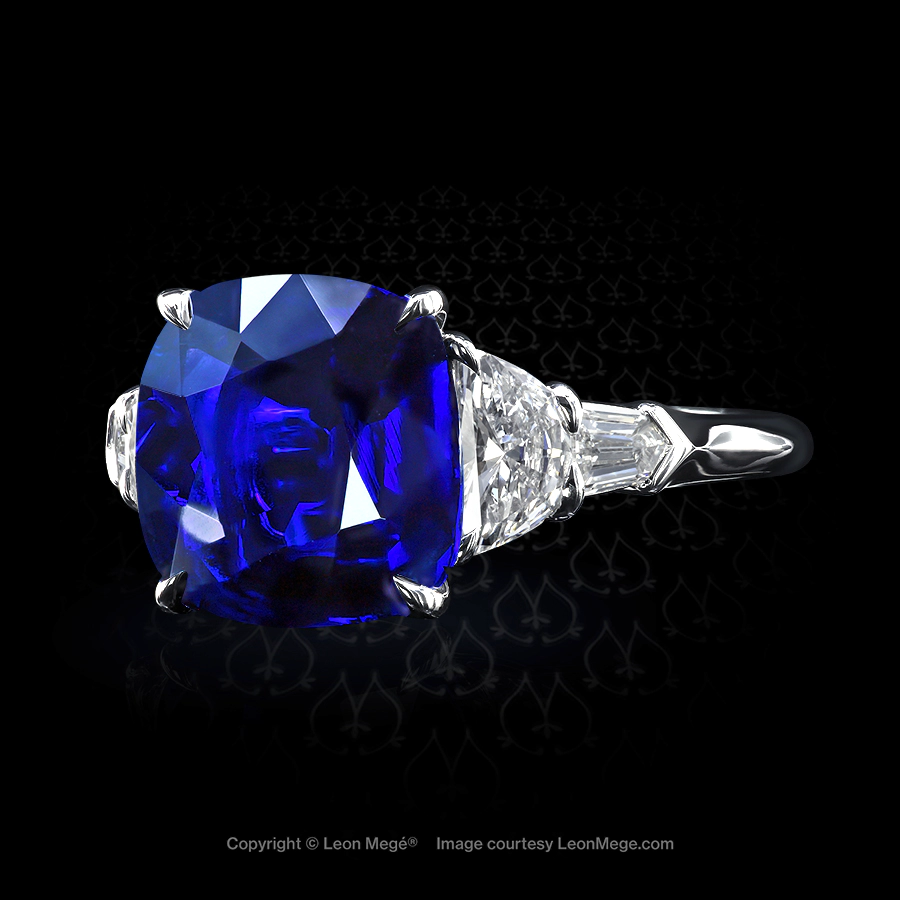 Classic five-stone ring featuring a cushion cut blue sapphire by Leon Mege.