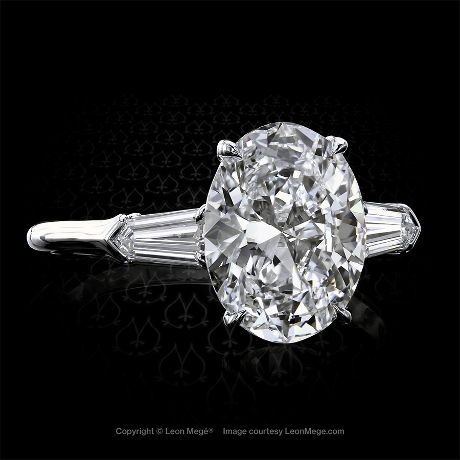 Custom made three-stone ring featuring an oval diamond by Leon Mege.