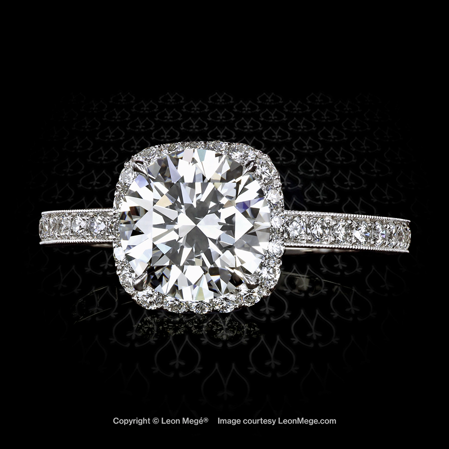 Custom made halo ring featuring a round diamond in a cushion halo with pave by Leon Mege.