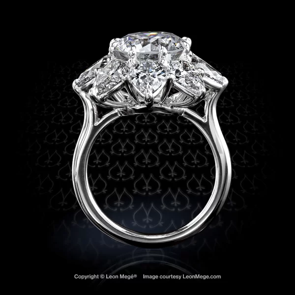Round diamond in a clusre ring with pear shape diamonds made in platinum by hand by Leon Mege