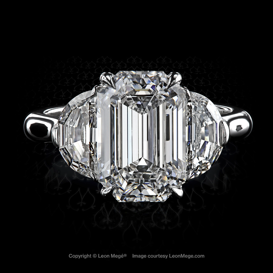 Three stone ring with emerald cut diamond and step cut half moon diamonds in a platinum setting by Leon Mege