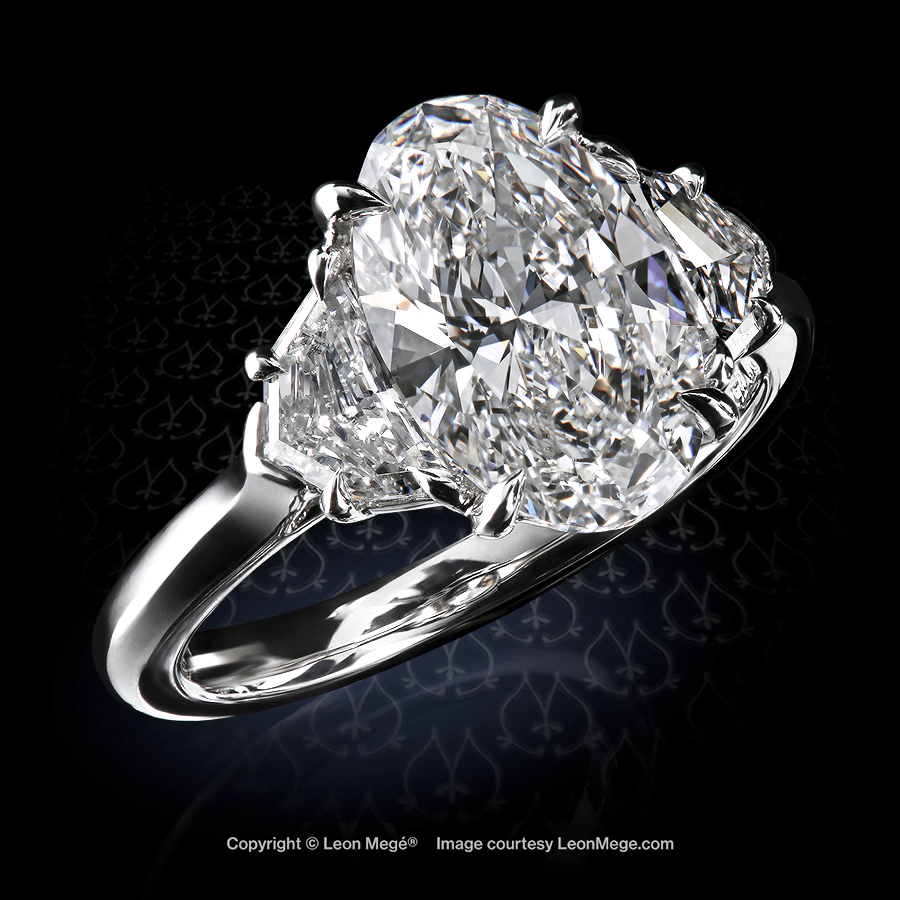 Classic three-stone ring featuring 2.01 carat oval diamond with epaulettes handmade by Leon Mege