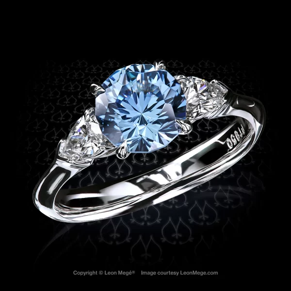 Classic three-stone ring, featuring 1.94 carat round light blue sapphire by Leon Mege.