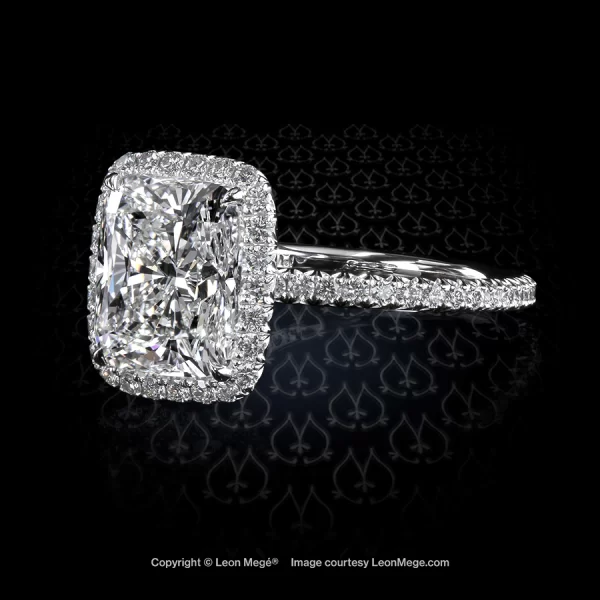 Modern cushion diamond with micro pave halo with small diamonds on the shank in platinum engagement ring by Leon Mege