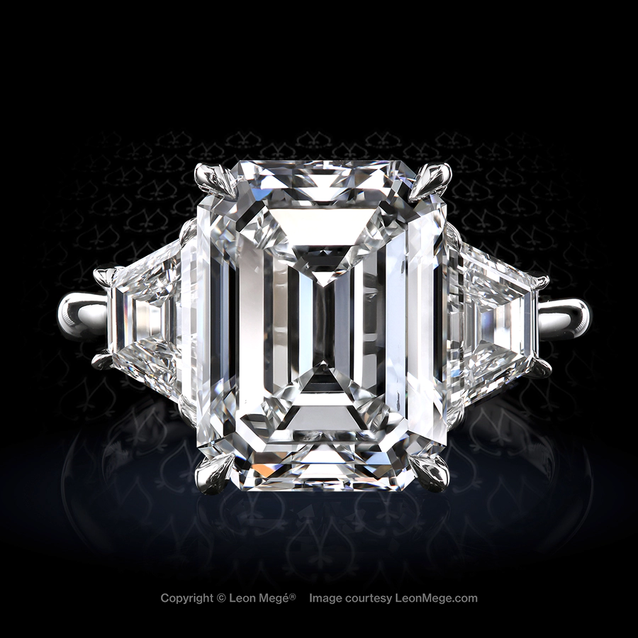 Bespoke three-stone platinum ring made by Leon Mege Jewelers set with emarald-cut diamond and diamond trapezoids.