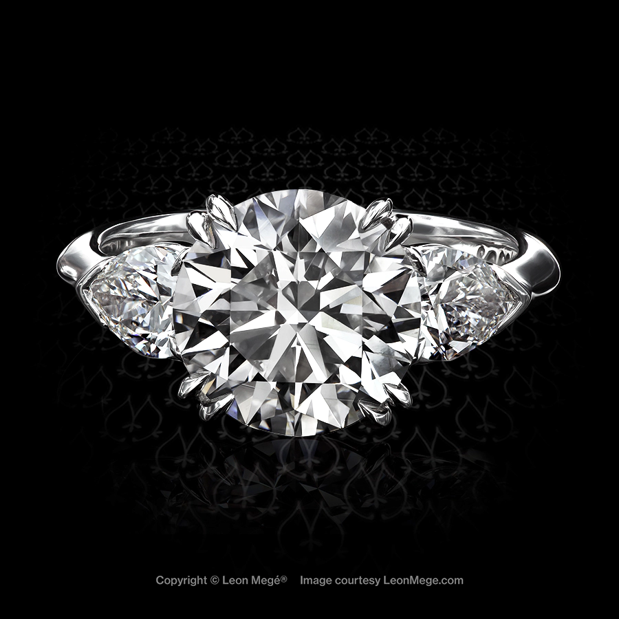 Classic three-stone ring fearing round and pear-shape diamonds by Leon Mege.
