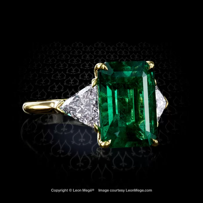 Three-stone ring with fine Colombian emerald and diamond trillions on the side by Leon Mege jewelers.