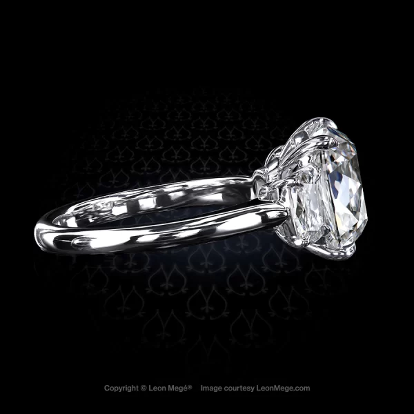 Classic three-stone ring, featuring 4.02 carat Antique cushion diamond with cushion diamond side stones set in platinum by Leon Mege.