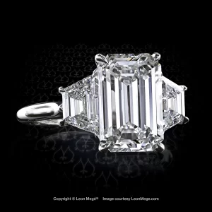 Classic three-stone ring, featuring 3.55 carat emerald cut diamond with diamond trapezoids