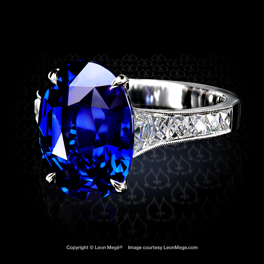 Leon Mégé Mon Chéri ring with a natural Royal-blue sapphire embraced by four claw prongs and a graduated channel of French-cut trapezoid diamonds r8736